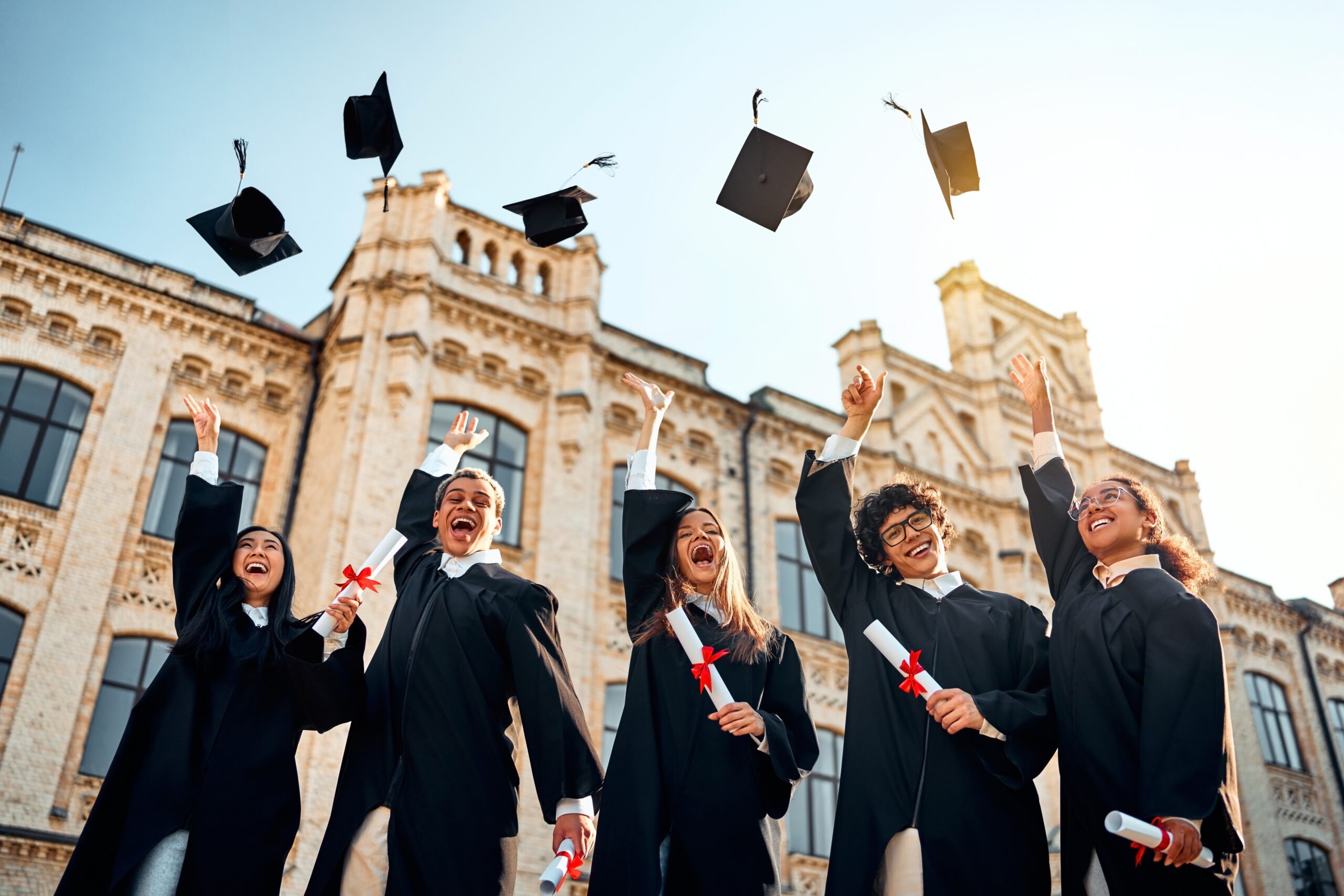 A group of fresh graduates throwing their cap